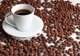 Hot Coffee Cup Surrounded by Roasted Brown Beans on a White Backdrop