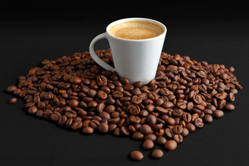 Black Background with a White Cup of Espresso coffee and Dark Roasted Beans