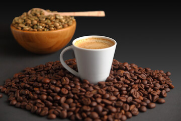 Espresso Surrounded by toasted Beans, with Green Coffee Beans in a Wooden Bowl