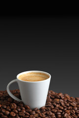 Espresso coffee in a White Cup Surrounded by Dark Roasted Coffee Beans