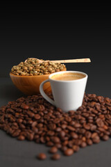 Close-Up of Espresso Coffee Surrounded by toasted Beans and Green Coffee Beans in a Wooden Bowl