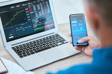 Man, smartphone and laptop or trading on stock market, fintech and analyse growth graphs for...