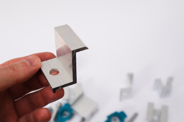 Hand Holding End Clamp of Solar PV Panel. Solar Panel Mounting.