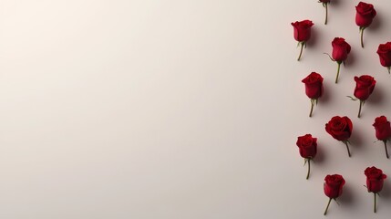 Obraz premium Fresh red roses are symmetrically arranged on a white surface, showcasing beauty and elegance while leaving space for text or branding on the left side