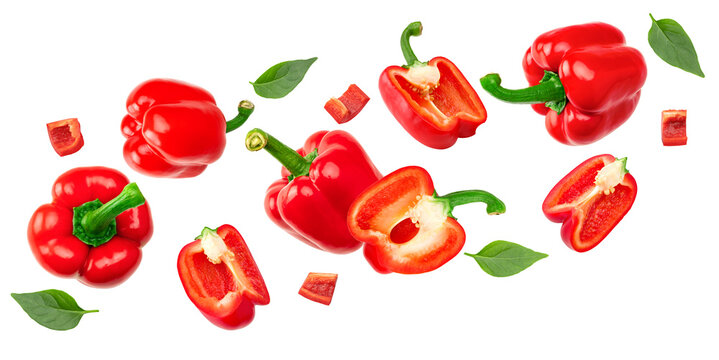 flying sliced red sweet bell pepper with green leaves isolated on white background. clipping path