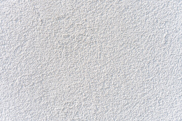White stucco wall texture under natural light, offering clean background surface ideal for design,...