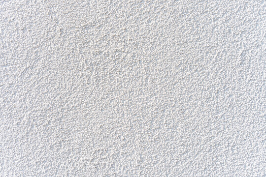 White stucco wall texture under natural light, offering clean background surface ideal for design, construction or architectural presentations