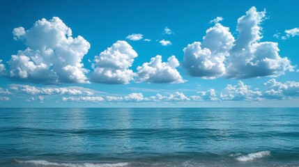 Obraz premium Ocean meets a sky full of fluffy white clouds on the horizon