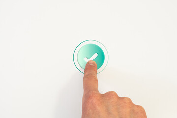Hand pressing circular button with checkmark on white background, representing confirmation,...