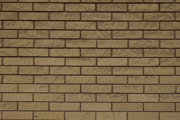 Dusty surface of beige split face brick veneer wall with running bond layout