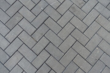 Background - grey concrete pavement with single herringbone layout
