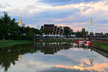 Fototapeta premium Golden Pagoda and Church, Lanna Architecture in Evening vibes with natural landscapes at Wat Pa Ratchadaram in Lamphun, Northern Thailand