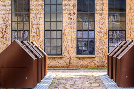 Symmetrical recycling stations with brown metal finishes in a courtyard setting in Copenhagen, promoting clean urban design and efficient waste management systems.