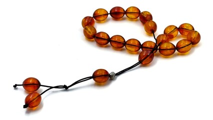 Photo of traditional orange worry beads (komboloi), isolated on a white background, showcasing...