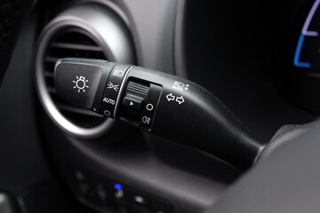 The light knob in the car. Multifunction Headlight Console Control Switch knob. Car interior with light switch. Headlight switch; Turn signal lever; Fog light switch.