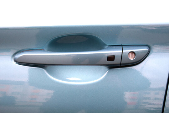Exterior blue car door handle with keyless entry button. Keyless entry car door handle with keyless go touch sensor. Automatic opening of a car door without a key. Car door handle. Access button.