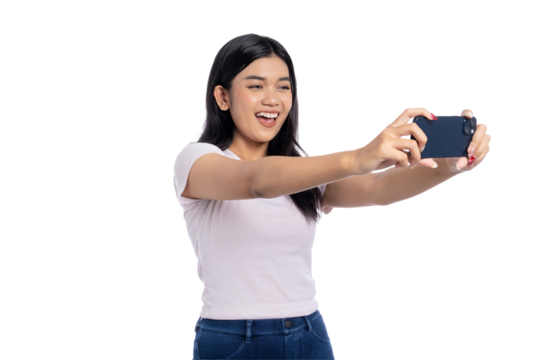 Happy young Asian woman taking a selfie with smartphone, smiling and posing, isolated on transparent background