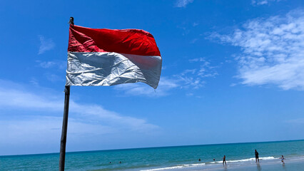 Fototapeta premium The Indonesian flag flutters in the blue sky