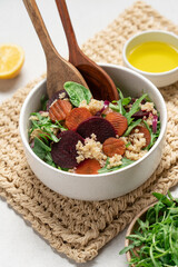 Quinoa salad with arugula, beetroot and carrot. Detox, diet, healthy salad in white bowl on light background