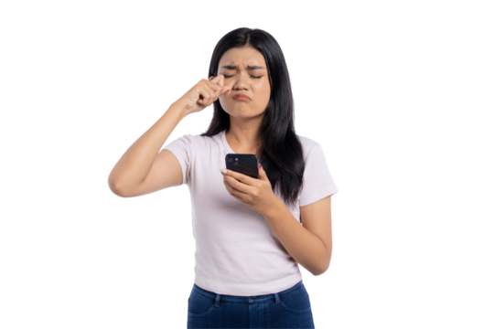 Young Asian woman feeling frustrated and rubbing her eyes while looking at her smartphone, isolated on transparent background