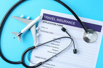 Medical tourism. Travel insurance application form, stethoscope and plane model on light blue...