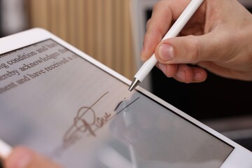 Electronic signature. Man using stylus and tablet indoors, closeup