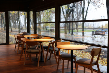 Stylish cafe with large windows and comfortable furniture. Interior design