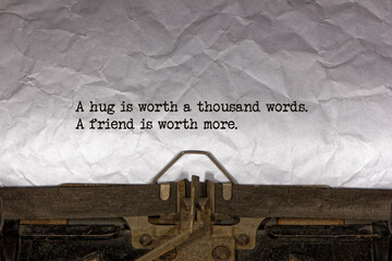A hug is worth a thousand words A friend is worth more close up of a phrase being typed and...