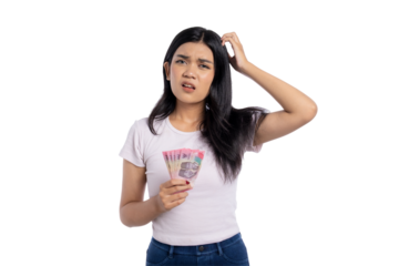 Confused young Asian woman scratching head while holding Indonesian rupiah banknotes, isolated on transparent background