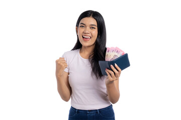 Happy young Asian woman celebrating success while holding a wallet full of Indonesian rupiah...