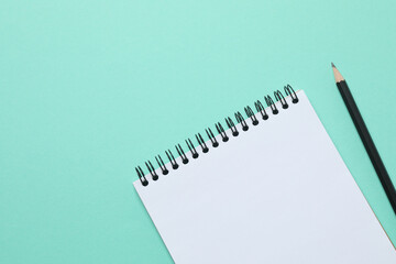 Top view photo of notebook with a pencil on color background with blank space. Business concept