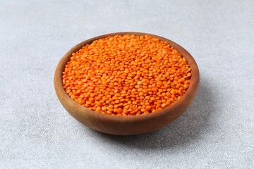 Red lentils in a bowl on a gray background