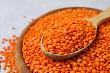 Red lentils in a spoon on a gray background