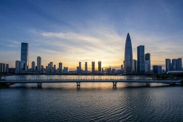 Sunset over modern city skyline and bridge.