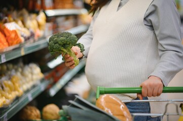 Beautiful pregnant woman shopping healthy food at grocery shop