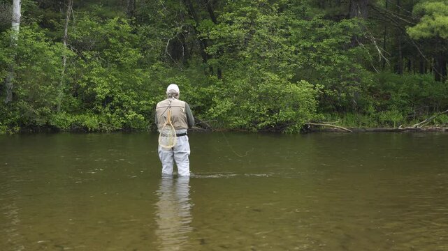 Man fly fishing on the South Branch of the Au Sable River at Smith Bridge near Grayling Michigan.