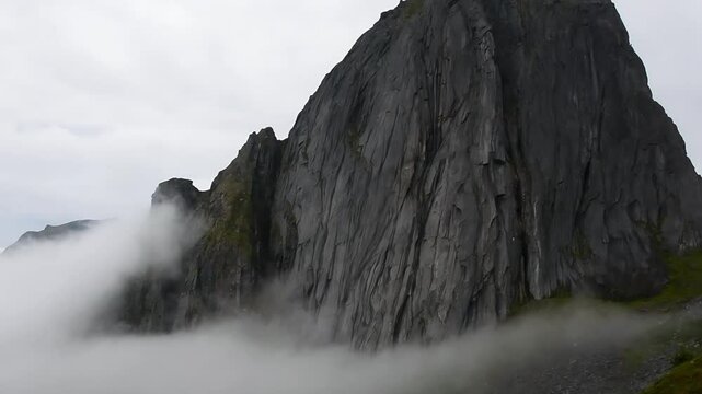 View of Mount Hesten on Iconic Mountain Segla Norway in light of epic sunsetcovered in fog, slow moution. High quality photo.Copy space.