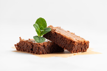 Pieces of chocolate brownies on a light background. Delicious and sweet homemade pastries for breakfast. Vegetarian dessert.
