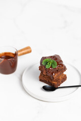 Pieces of chocolate brownies on a light background. Delicious and sweet homemade pastries for breakfast. Vegetarian dessert.
