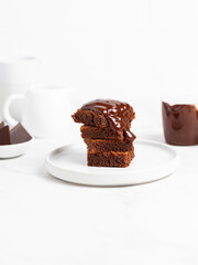 Pieces of chocolate brownies on a light background. Delicious and sweet homemade pastries for breakfast. Vegetarian dessert.
