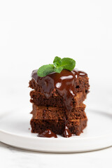 Pieces of chocolate brownies on a light background. Delicious and sweet homemade pastries for breakfast. Vegetarian dessert.
