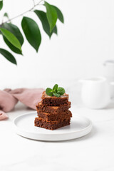 Pieces of chocolate brownies on a light background. Delicious and sweet homemade pastries for breakfast. Vegetarian dessert.
