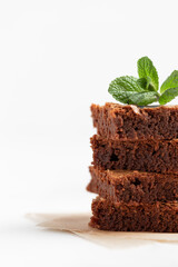 Pieces of chocolate brownies on a light background. Delicious and sweet homemade pastries for breakfast. Vegetarian dessert.
