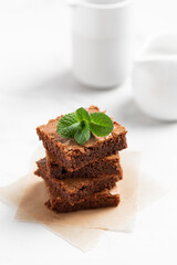 Pieces of chocolate brownies on a light background. Delicious and sweet homemade pastries for breakfast. Vegetarian dessert.
