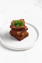 Pieces of chocolate brownies on a light background. Delicious and sweet homemade pastries for breakfast. Vegetarian dessert.
