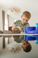 Curious Child Playing with Kinetic Sand Indoors