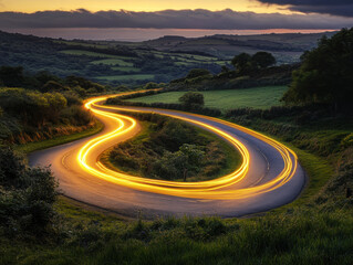 Winding road illuminated by vehicle lights at dusk in the countryside