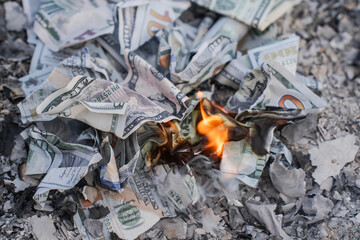 Burning US Dollar Bills on Ashes Representing Financial Loss and Waste