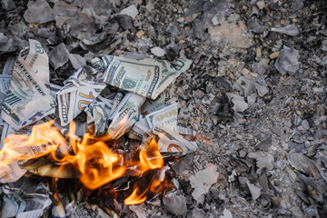 Burning US Dollar Bills on Ashes Representing Financial Loss and Waste