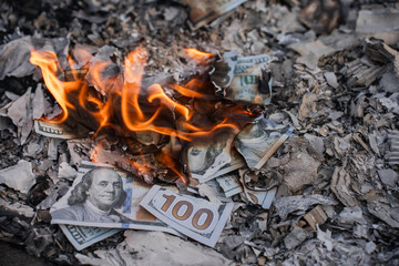 Burning US Dollar Bills on Ashes Representing Financial Loss and Waste